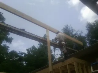 Carpenter setting a ridge beam over a new addition frame — Ice Dam Removal by Roofing Brothers in Oriskany