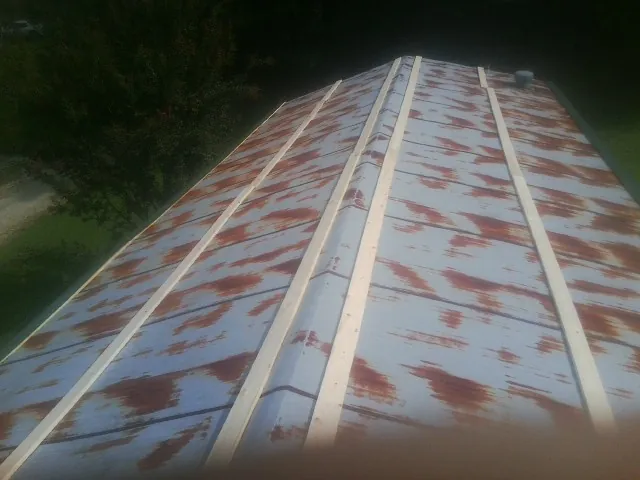 Rusted metal roof panels with new wood purlins before replacement — Storm Damage Roof Repair in Oriskany by Roofing Brothers
