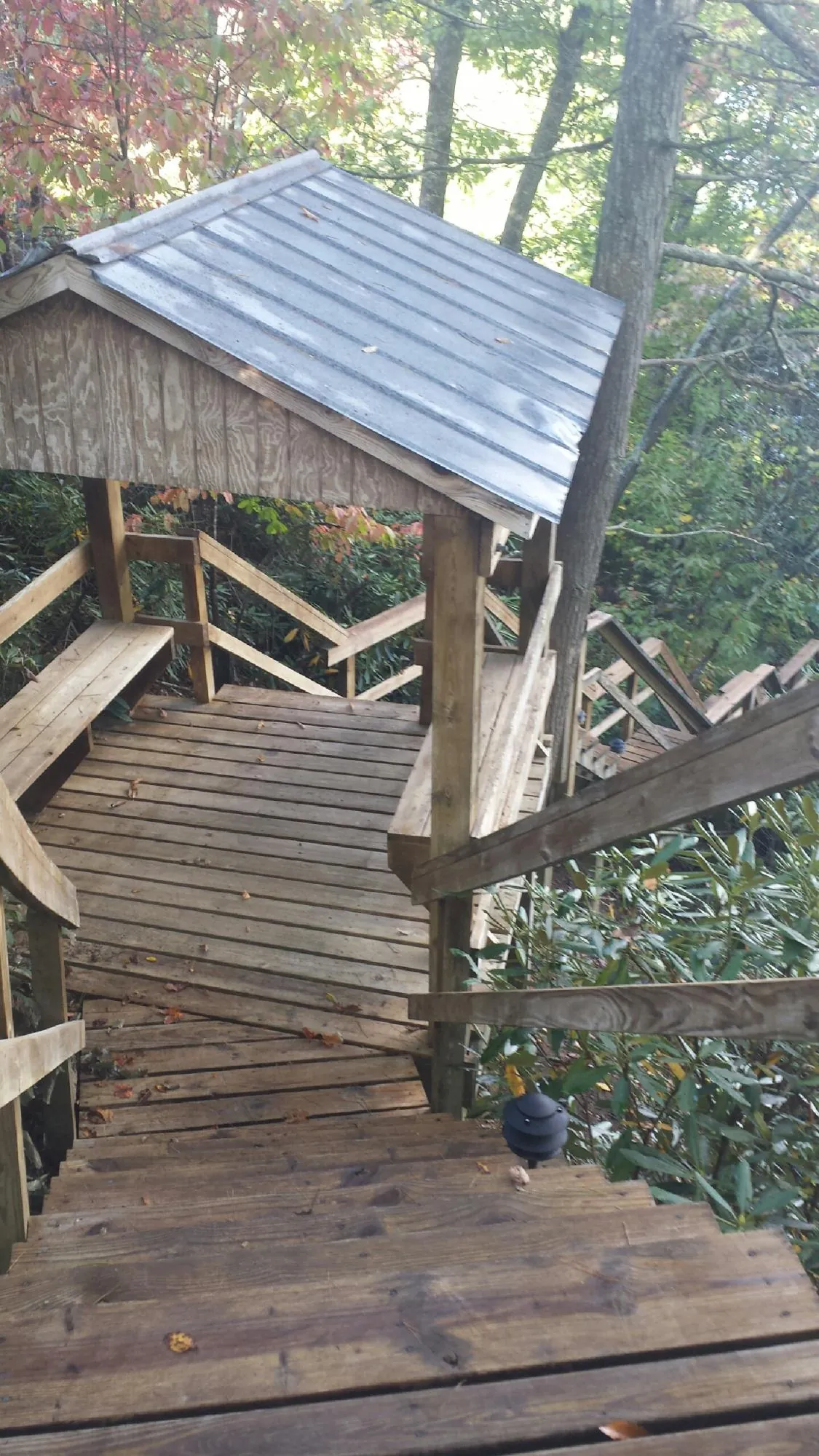 Metal roofed shelter over wooden steps on a wooded walkway — Skylight Repair & Installation work by our crew in Oriskany