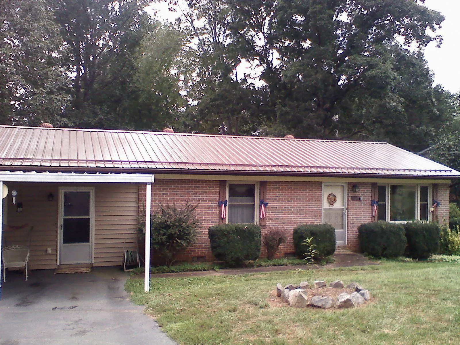 Bronze metal roof and carport on a brick ranch home — Roof Repair work by our crew in Oriskany